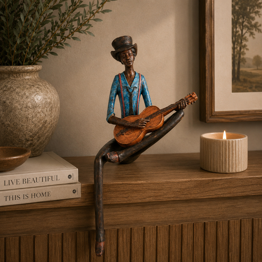 A decorative figurine of a man playing a guitar, styled on a wooden mantelpiece next to a lit candle, books, and a potted plant.